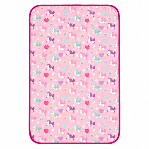 A rectangular pink blanket or mat with rounded corners, featuring a repeating pattern of cartoon unicorns, hearts, and rainbows, finished with a bright magenta border.