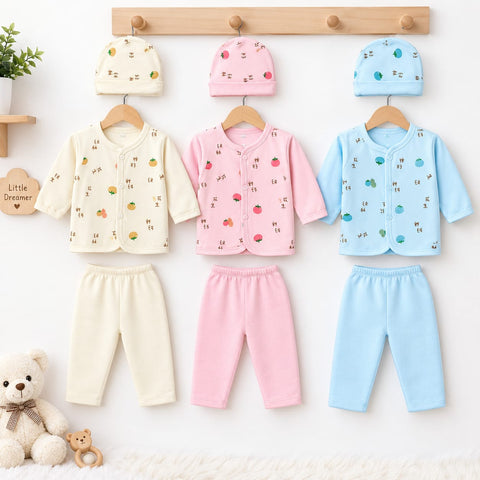 Three sets of baby clothing displayed on wooden hangers against a white wall: a cream long-sleeve top with matching cream pants, a pink long-sleeve top with matching pink pants, and a light blue long-sleeve top with matching blue pants. Each set includes a matching hat.