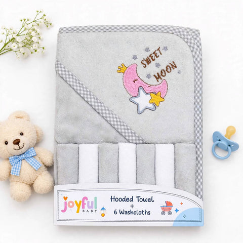 A gray hooded baby towel set with six washcloths, featuring a pink crescent moon, yellow star, and 'SWEET MOON' embroidery on the hood, shown with a plush teddy bear, baby flowers, and a pacifier on a white background.
