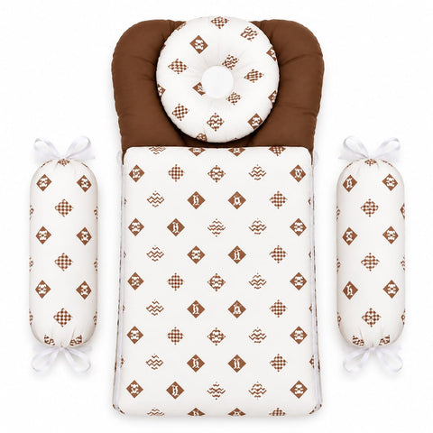 A baby bedding set featuring a changing pad or bassinet insert with a brown and white geometric pattern, a matching circular pillow, and two cylindrical support pillows with white bows, all arranged on a plain white background.