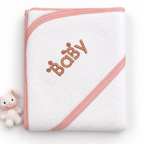 A folded white baby hooded towel with pink trim and an embroidered 'BABY' text design in a warm brown tone, shown on a white background with a small plush bunny toy at the lower left.