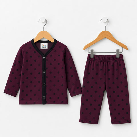 A two-piece baby clothing set consisting of a long-sleeve cardigan and matching pants, both in a deep burgundy color with black polka dots. The cardigan features a black button placket and collar, and is shown hanging on a wooden hanger alongside the matching pants on a light gray background.