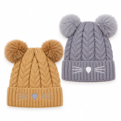 Two cable-knit baby beanies with faux fur pom-poms on top and cat-face embroidered details on the cuff, shown on a white background. One beanie is camel tan and the other is heather gray.