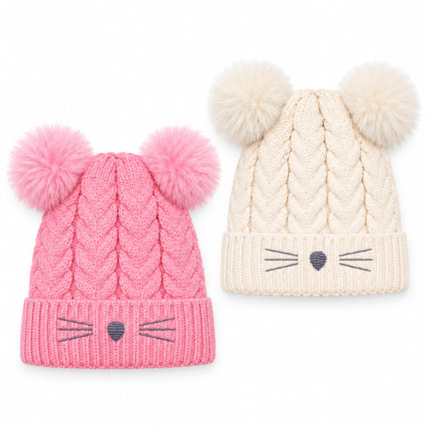 Two cable-knit baby beanies with pom-poms, shown side by side on a white background. The left hat is pink with a pink pom-pom and embroidered cat face details.