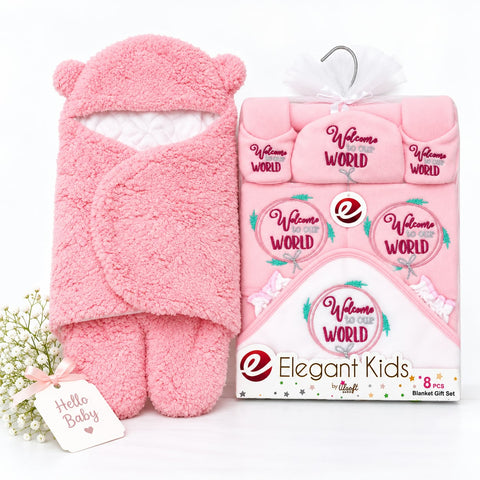 Pink baby blanket gift set including a plush hooded blanket with bear ears, matching footed socks, and a folded set in retail packaging. The items are pink with white and magenta text reading 'Welcome Baby to the World' and 'Hello Baby.