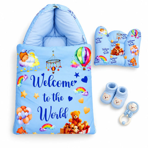 A baby bedding set on a white background, featuring a light blue hooded blanket with colorful cartoon prints and the words 'Welcome to the World,' plus matching pillow, bumper, booties, and teething ring.