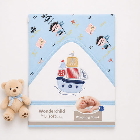 A baby wrapping sheet with a light blue hooded border and a central white panel featuring an embroidered pirate ship design. The sheet is shown on a white background next to a small beige teddy bear.