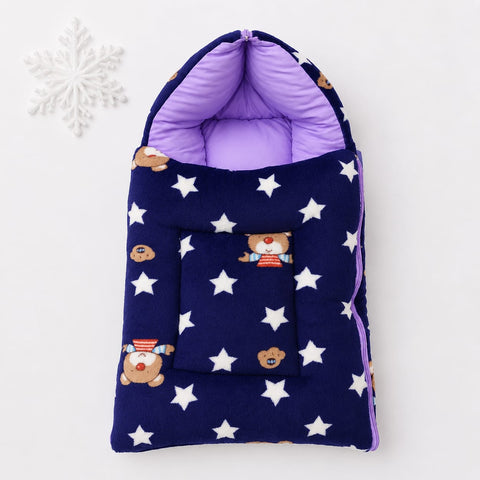 A baby hooded sleep sack in navy blue with white stars and teddy bear prints, featuring a purple interior lining and a matching zippered pocket, displayed on a white background with a white snowflake ornament.