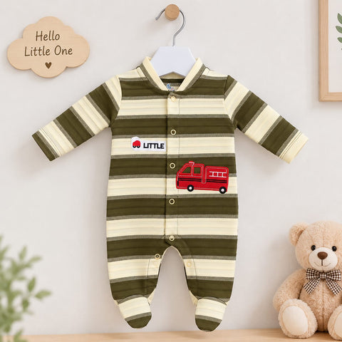A baby long-sleeve footed sleeper with olive green and cream horizontal stripes, featuring a red fire truck graphic and a 'LITTLE' logo patch on the chest. The sleeper is displayed on a white hanger against a light wall, styled with a wooden 'Hello Little One' cloud sign and a plush teddy bear.