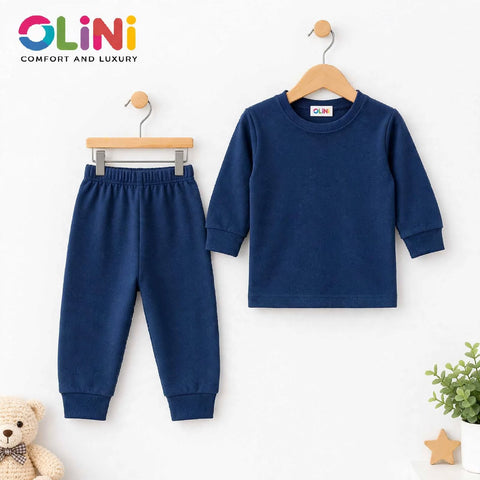 A two-piece children's outfit set in navy blue, featuring a long-sleeve crewneck top and matching jogger pants, displayed on wooden hangers against a white wall. The brand logo 'OLiNi' is visible in the top left corner and on the inner neck label.