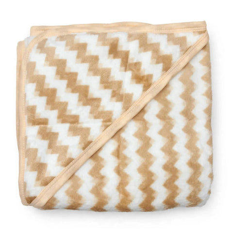 A folded plush blanket featuring a beige and white chevron pattern with a solid beige border and matching diagonal tie-on strap, shown on a clean white background.