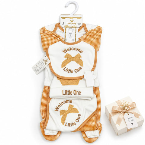 A baby bib and footie onesie set by JoJo's Baby, featuring a white bib with gold embroidered text and bow, orange-and-white gingham trim, and matching footie sleeves. A small gift box is placed beside it on a clean white background.
