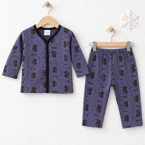 A two-piece children's pajama set hanging on wooden hangers against a white wall. The set includes a long-sleeve top and matching pants in a dusty purple fabric with an all-over print of brown and purple toy cars and small icons, finished with a black collar and front zipper.