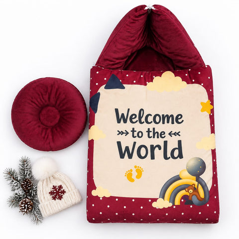 A baby welcome home bag set featuring a burgundy and cream fabric bag with the text 'Welcome to the World' and a rainbow graphic, accompanied by a matching burgundy circular cushion and a cream knit baby hat with a snowflake, styled on a white background.