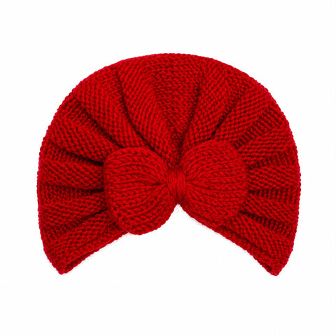 A bright red chunky-knit baby turban hat with a large bow at the center, shown against a plain white background.