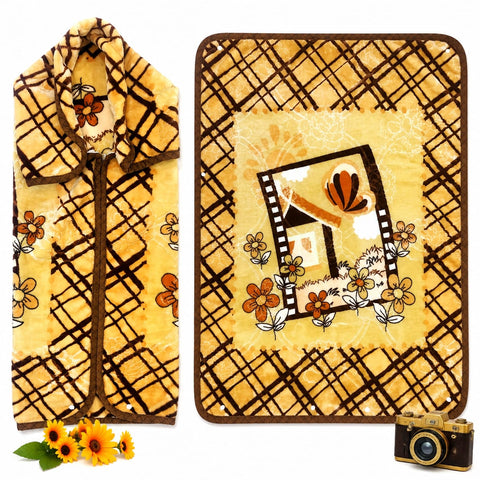 A yellow fleece blanket with a brown plaid pattern and a central floral house design, shown folded on the left and laid flat on the right. The blanket features a warm yellow base with brown grid lines, orange flowers, and a small house illustration in the center.