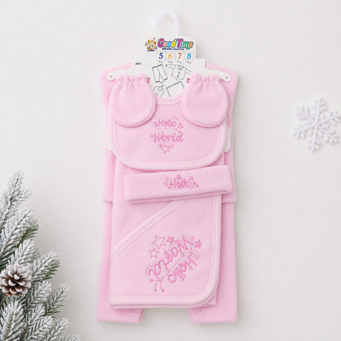 A pink baby gift set hanging on a white hanger against a light background, featuring a bib with 'Hello World' embroidery, a matching hat, and a hooded towel with 'My First Party' embroidery. Decorative pine branches and a snowflake are visible at the edges.