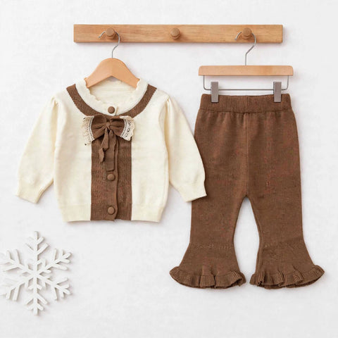 A toddler girl's two-piece knit outfit set featuring a cream cardigan with brown trim and a matching brown ruffled flared pant, displayed on wooden hangers against a light background.