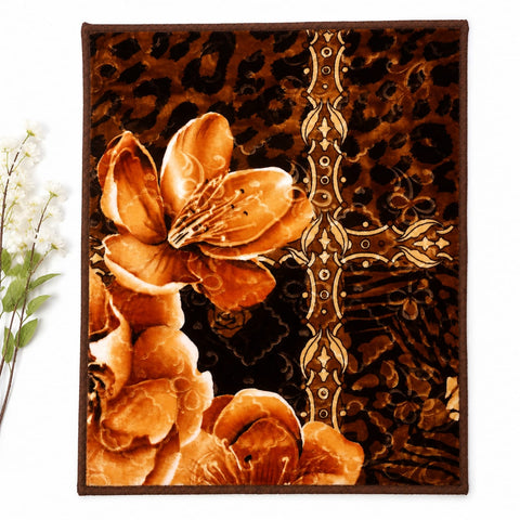 A rectangular area rug with a brown and black leopard print background, featuring large orange-brown floral motifs and an ornate vertical gold-toned decorative motif. The rug is shown flat against a white background with a small decorative plant branch at the left edge.