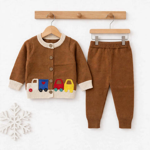 A toddler two-piece knit outfit set consisting of a brown cardigan sweater with cream trim and a colorful train applique, paired with matching brown pants, displayed on wooden hangers against a white background.