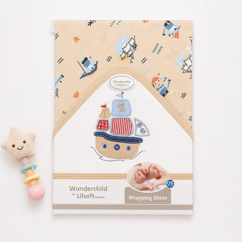 Wonderchild Lilsoft Fashion baby wrapping sheet with a beige and white design featuring a colorful embroidered-style pirate ship illustration and nautical print, shown on a white background with a small plush rattle prop.