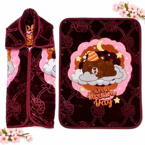 A plush fleece blanket and matching zippered pouch shown on a white background with decorative pink flowers. The blanket features a dark burgundy floral pattern, a central pink cloud design with a sleeping brown bear on clouds and stars, and the words 'World Dream Day.