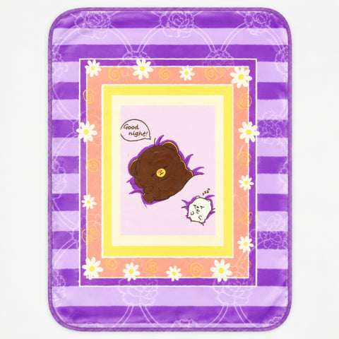 A square decorative mat or rug with rounded corners, featuring a purple and lavender striped border, white daisy flowers, and a central illustration of a sleeping brown bear with a speech bubble that says 'Good night!'.