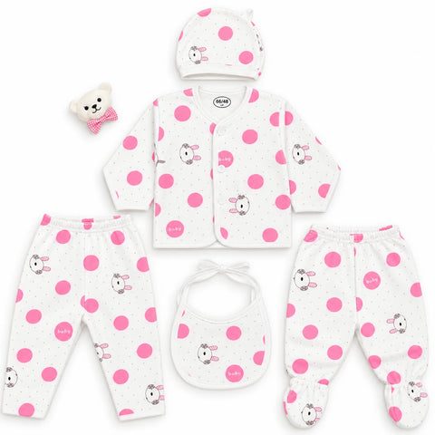 A 6-piece baby clothing set laid out on a white background, including a cardigan, pants, footed sleeper, bib, hat, and a small teddy bear accessory. The set is white with pink polka dots and cartoon bunny prints.