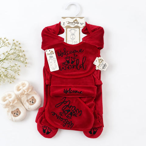 A red baby footie onesie set with a matching belly band and booties, displayed on a white background with a hanger. The set features 'Welcome to the world' text and black footprints.