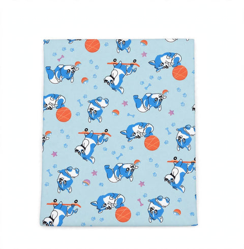 A square fabric item, likely a blanket or towel, featuring a light blue background with a playful pattern of cartoon French bulldogs rolling up their blue and white sweaters, alongside orange basketballs, pink stars, and small rainbow accents.