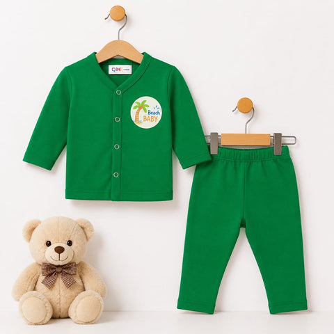 A two-piece baby outfit set consisting of a green long-sleeve button-front cardigan and matching green pants, displayed on wooden hangers against a white background, with a beige teddy bear sitting below.