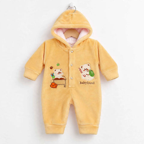 A yellow hooded baby jumpsuit with a plush fleece texture, featuring cartoon bear graphics and 'baby found' text on the front, displayed on a wooden hanger against a white background.