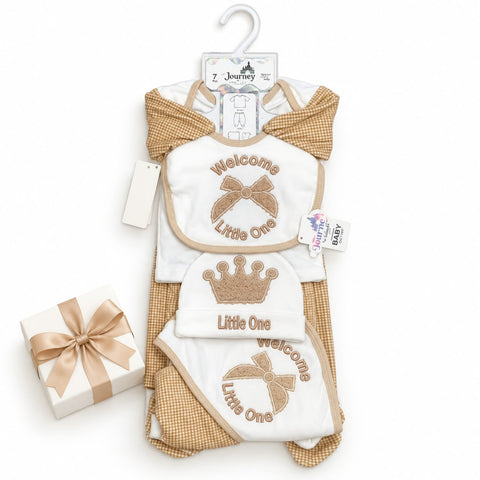 A baby gift set featuring a white and tan checkered romper, a matching bib, and a bootie with 'Welcome Little One' and crown designs, displayed on a hanger next to a small wrapped gift box on a white background.