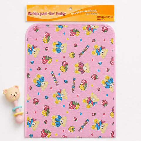 A pink quilted baby diaper pad with a cartoon teddy bear and strawberry pattern, shown with its orange header packaging and a small bear teether toy on a white background.