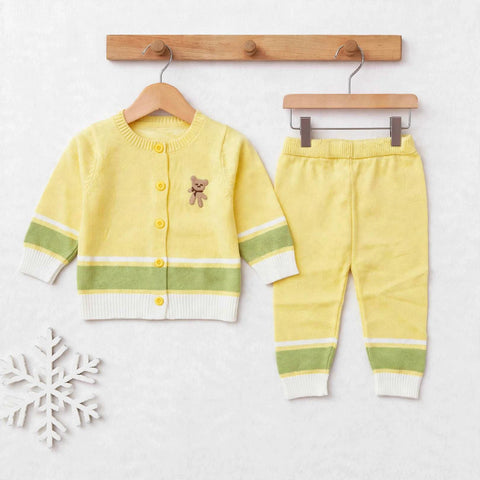 A baby knit two-piece outfit set consisting of a yellow cardigan sweater with green and white stripes, a matching yellow pair of pants with white and green stripes, displayed on wooden hangers against a light textured background.
