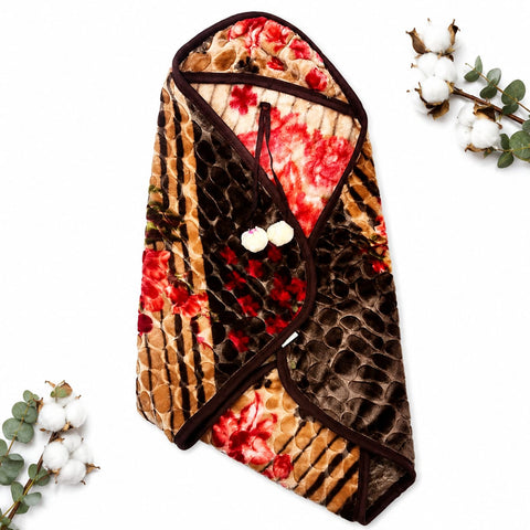 A plush quilted blanket with a mixed pattern of brown snakeskin, red floral, and tan leopard print, styled on a white background with decorative cotton stems.