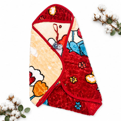 A folded quilted baby blanket or swaddle with a red velvet-textured side, a cream quilted side, and colorful floral and cloud patterns, styled on a white background with cotton stems in the corners.