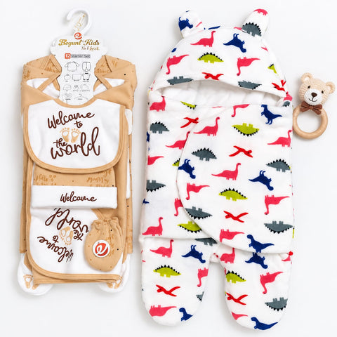 A baby gift set featuring a tan and white 'Welcome to the World' footed blanket with a hanger, and a white footed blanket with a colorful dinosaur print and a hood with bear ears, accompanied by a wooden bear teething ring.