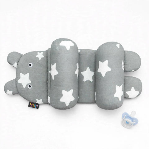 A gray and white star-patterned baby support pillow shaped like a caterpillar, shown on a white background with a small blue pacifier nearby.