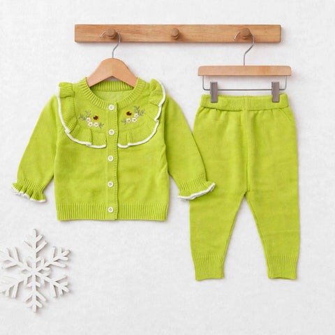 A toddler girl's two-piece knit outfit set consisting of a lime green cardigan with a ruffled collar and embroidered flowers, paired with matching lime green pants, displayed on wooden hangers against a light gray background.