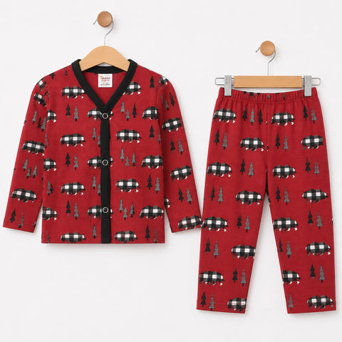 A two-piece children's pajama set including a long-sleeve button-front cardigan and matching pants, both in red with a repeating pattern of black-and-white buffalo plaid logs and dark green pine trees, displayed on wooden hangers against a white background.