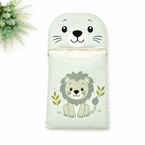 A baby sleeping bag or pouch in pale mint green, featuring a cartoon lion illustration on the front and a matching lion face hood. The pouch is shown on a white background with a decorative green plant in the top-left corner.