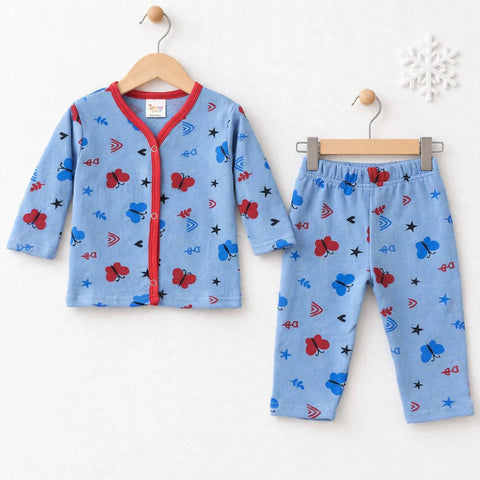 A two-piece children's pajama set consisting of a light blue long-sleeve cardigan and matching pants, decorated with a playful pattern of red ladybugs, blue butterflies, black stars, and red/blue geometric shapes. The cardigan features a red trim and snap-button front, hanging on a wooden hanger against a white background.