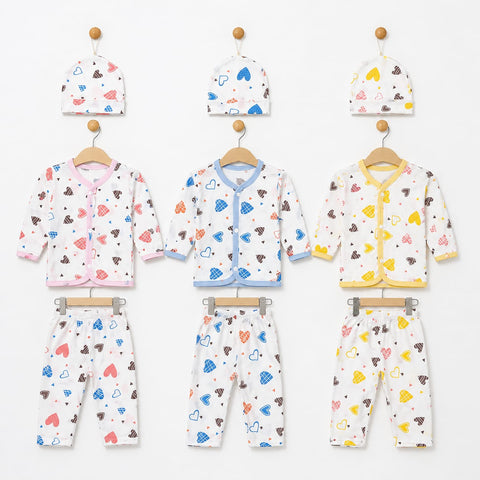Three baby clothing sets hanging on wooden hangers against a white wall, each set including a hat, cardigan, and pants. The sets are white with colorful heart and cloud prints in pink, blue, brown, and yellow, with different trim colors (pink, blue, and yellow).
