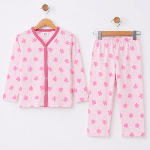 A two-piece children's pajama set hanging on wooden hangers against a plain white wall. The set includes a long-sleeve button-front top and matching pants, both in light pink with a darker pink maple leaf pattern and pink trim.