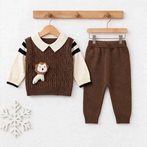 A baby clothing set displayed on wooden hangers against a light background. The set includes a brown cable-knit vest with cream sleeves, black sleeve stripes, a cream collar, and a small lion applique on the chest, paired with matching brown pants.